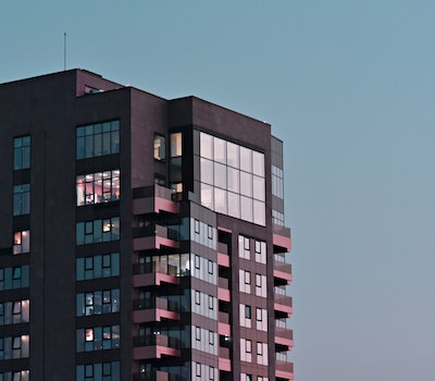 Immobilier neuf France | Birdy Promotion. Image représentant un immeuble de couleur noire avec vitres teintées, ciel bleu. @pexels-dids-2033332